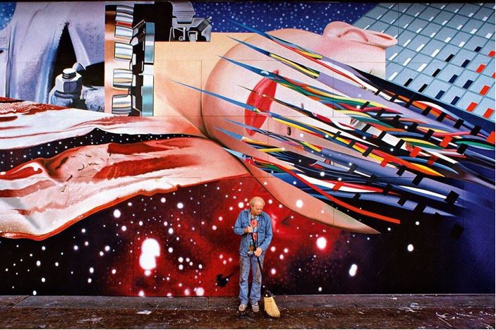 Photo of James Rosenquist in front of one of his paintings