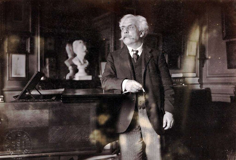 Faure standing by piano